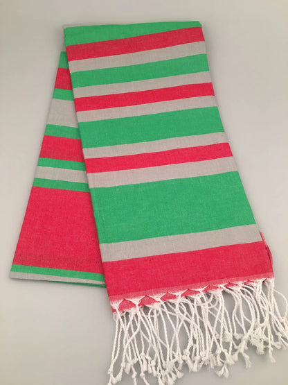 "Turquoise and coral striped Turkish towel with grey stripes and white fringe, laid flat on a light background."